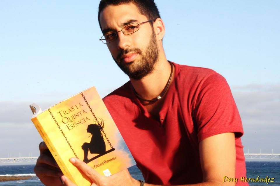 Jorge Cáceres Hernández con un ejemplar de 'Tras la quinta esencia' retratado por Dory Hernández.
